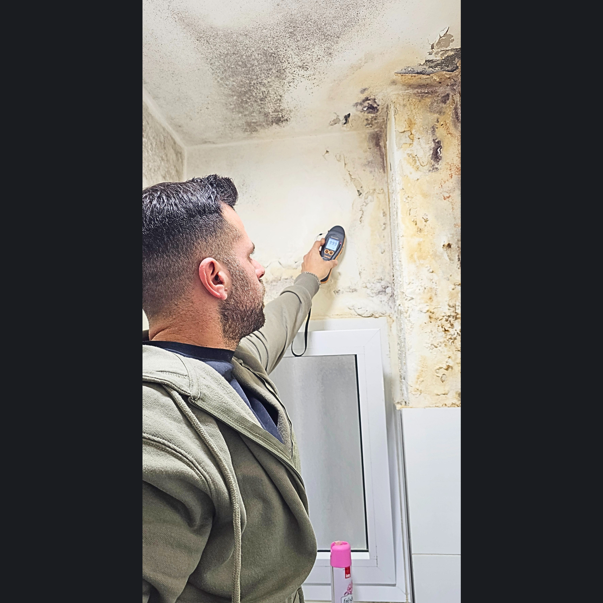 בודק בית מודד לחות עם מד רטיבות בפינת תקרה